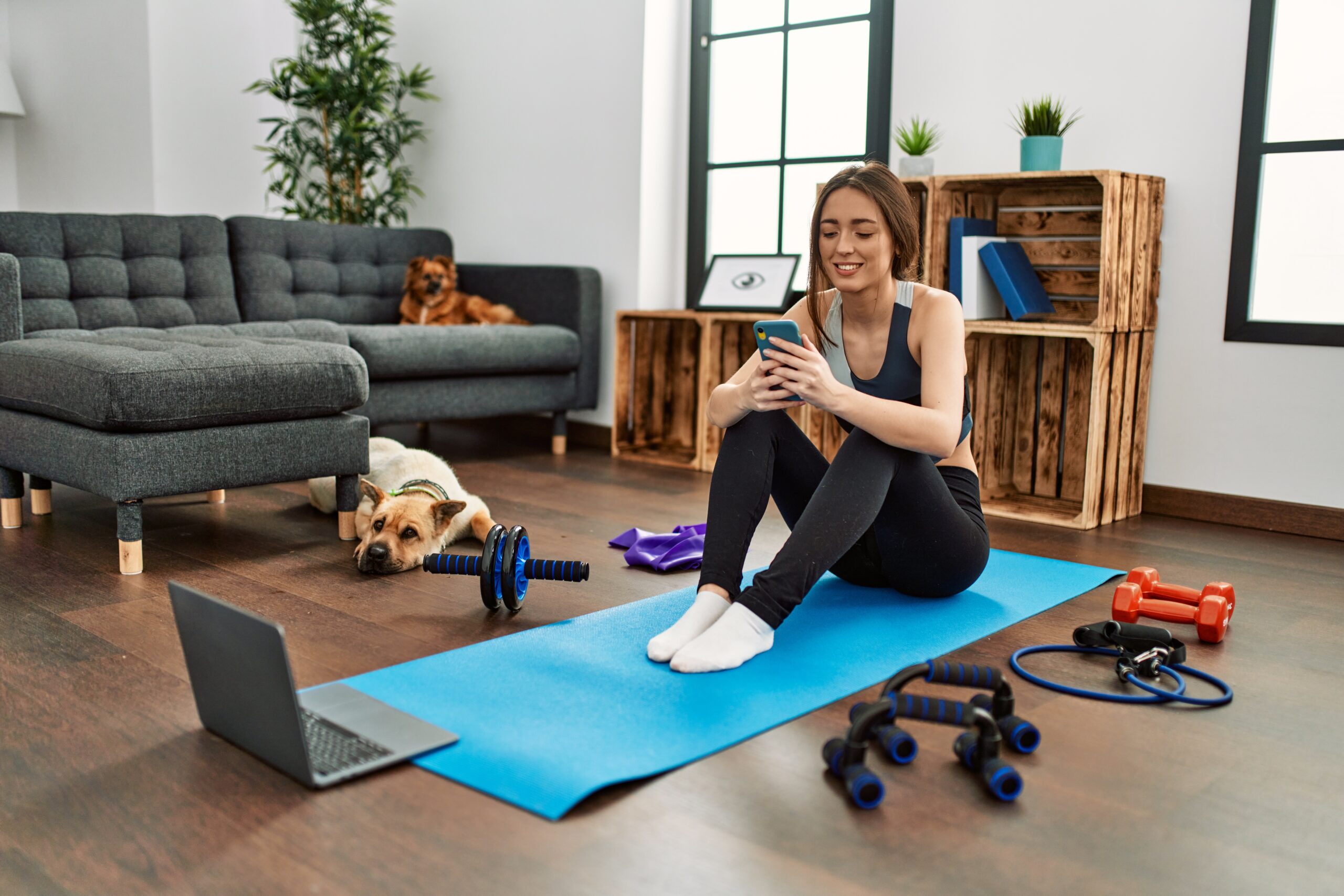 young hispanic woman sportswoman smiling confident using smartphone at home